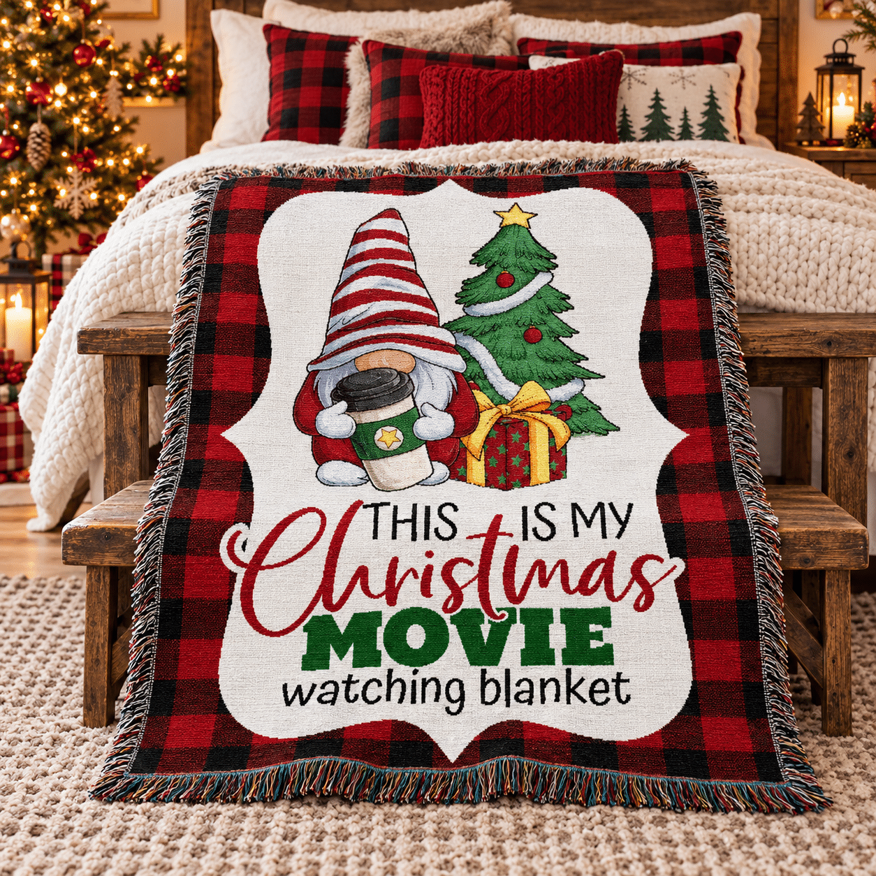 A blanket with a gnome, Christmas tree, gifts, and the text This is my Christmas movie watching blanket is draped on a bench at the foot of a cozy, decorated bed with holiday pillows in a festive bedroom.