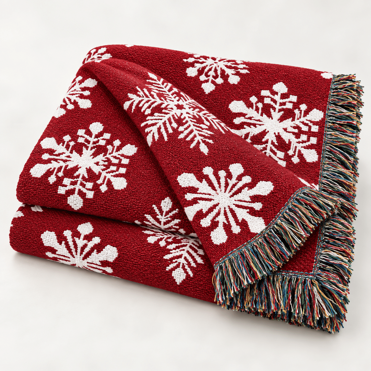 USA Made 100% Cotton Woven Throw Blanket - Snowflakes Red, featuring white snowflake patterns and multicolored fringe, displayed on a light background.